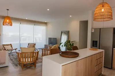 a kitchen and living room with a counter and chairs at Aldea 2BR Boho Style for 4 with Gym, Pool and Cowork in Paracas
