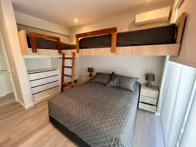 a bedroom with two bunk beds and a bed at Aldea 2BR TVs, KamadoBBQ for 6, Gym,Pool and Cowork in Paracas