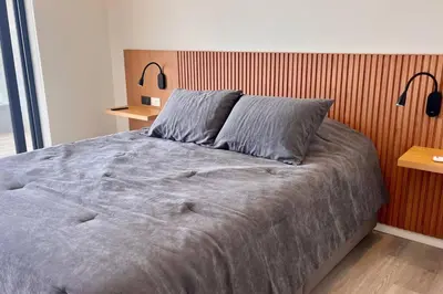 a bedroom with a large bed with a wooden headboard at Aldea 2BR, Service Room and Ocean View for 7 in Paracas