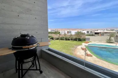 a grill with a view of a swimming pool at Aldea 2BR Ocean View and Kamado BBQ for 6 in Paracas