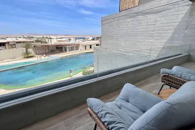 a view of a swimming pool from the balcony of a house at Aldea 2BR Ocean View and Kamado BBQ for 6 in Paracas