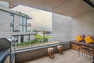a balcony with a couch and chairs on a building at Aldea 2 Bedroom with Private Sauna for 4 in Paracas