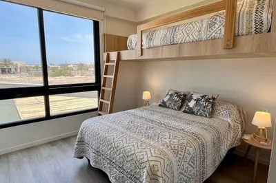 a bedroom with a bed and bunk beds with a window at Aldea 3 Bedroom Terrace Escape with Service Room in Paracas