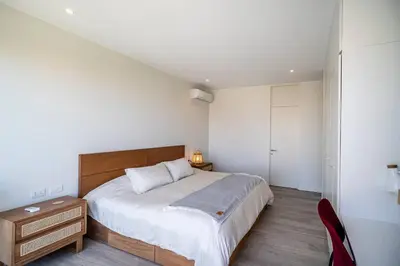 a bedroom with a large bed and a red chair at Aldea 1BR Romance Seascape for 2 in Paracas