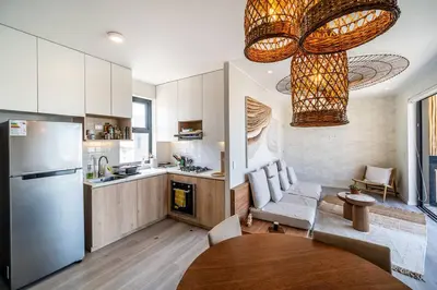 a kitchen with a refrigerator and a table in a room at Aldea 1BR Romance Seascape for 2 in Paracas