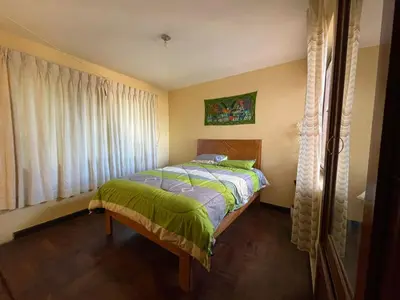 a bedroom with a bed and a window at Departamentos Belén in Cusco