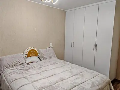 a bedroom with a large bed and white cabinets at Departamento Amoblado en Lince in Lima