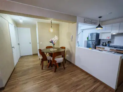 a kitchen and dining room with a table and chairs at Departamento Amoblado en Lince in Lima