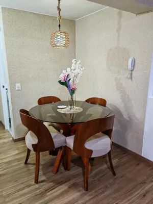 a dining room table with chairs and a vase of flowers at Departamento Amoblado en Lince in Lima