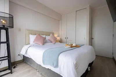 a bedroom with a large white bed with pink pillows at Connect Apartment by Vibrant in Lima