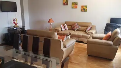 a living room with two couches and a glass table at Residencial Pardo in Lima