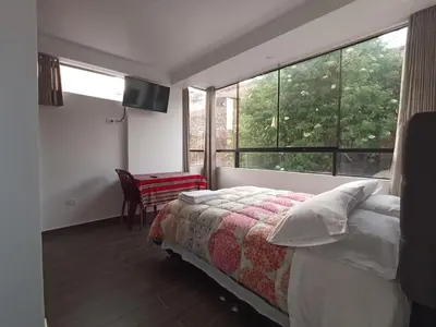 a bedroom with a bed and a large window at Casa Mónaco in Cusco