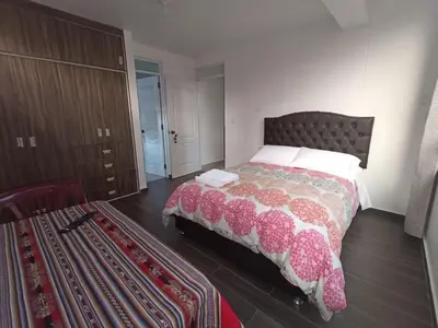 a bedroom with a bed and a dresser at Casa Mónaco in Cusco