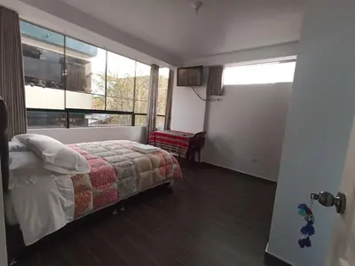 a bedroom with a bed and a large window at Casa Mónaco in Cusco