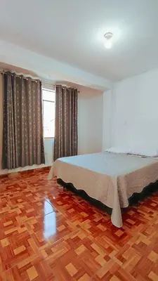 a bedroom with a bed and a wooden floor at CASA RICARDO PALMA con PISCINA in Ricardo Palma