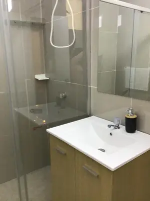 a bathroom with a sink and a shower with a mirror at Hernandez suites Suite203 in Lima