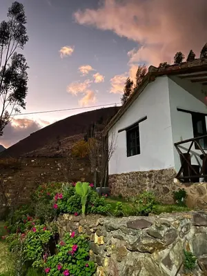 a white house with flowers in front of it at Tika bungalows hotel in Ollantaytambo