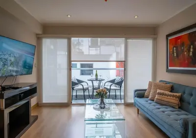 a living room with a couch and a table with chairs at Luxury Flat Miraflores Pool Gym Fast WiFi Balcony in Lima