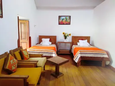 a room with two beds and a couch in it at Casa San Pedro Cusco in Cusco