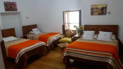 a room with two beds and a window at Casa San Pedro Cusco in Cusco
