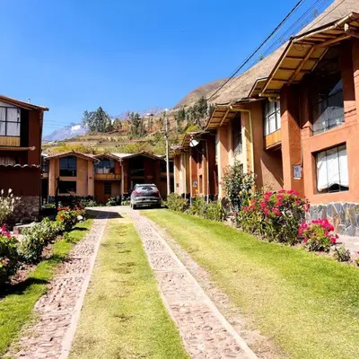 a car is parked in front of a house at Casa ecológica con vista a las montañas in Urubamba
