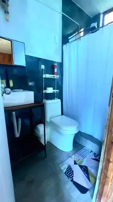 a bathroom with a white toilet and a sink at Vista al valle in Oxapampa