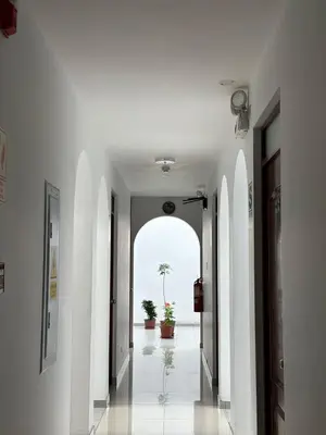 an empty hallway with white walls and an archway at Hostal El Rey in Lima
