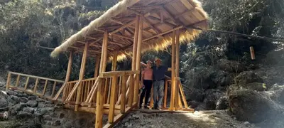 two people standing on a wooden bridge at EcoLodge Mayu Camping in Cusco