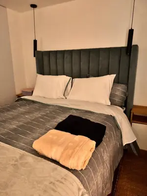 a bed with a black headboard and a brown blanket at betoben in Lima