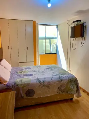 a bedroom with a bed and a television in it at Omi's Room 2 in Lima