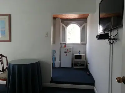 a hallway with a room with a refrigerator and a window at B&B El Olivar in Lima