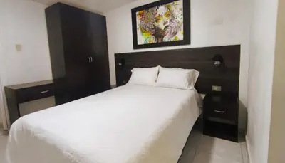 a bedroom with a large white bed and two night stands at Departamento centro in Andahuaylas