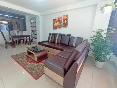 a living room with a leather couch and a table at Cusco Perú Apartment in Cusco