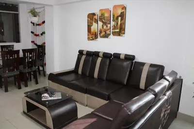 a living room with a leather couch and a table at Cusco Perú Apartment in Cusco