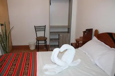 a bed with two swans made out of towels at Cusco Perú Apartment in Cusco