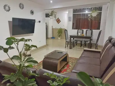 a living room with a couch and a tv and a table at Cusco Perú Apartment in Cusco