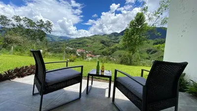a patio with two chairs and a table with a view at Göttlich Boutique Hotel in Pozuzo