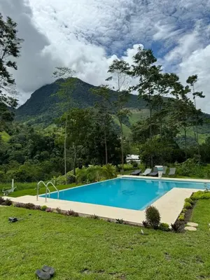 a swimming pool with a mountain in the background at Göttlich Boutique Hotel in Pozuzo