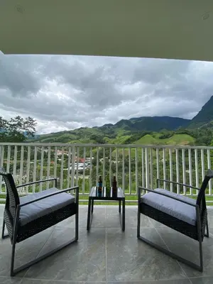 two chairs and a table on a balcony with a view at Göttlich Boutique Hotel in Pozuzo