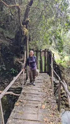 a woman walking on a wooden bridge at EcoLodge Mayu Camping in Tanca
