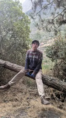 a young man sitting on a tree branch at EcoLodge Mayu Camping in Tanca
