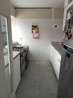 a small kitchen with a stove and white walls at Lindo mini apart Pueblo libre Lima in Lima