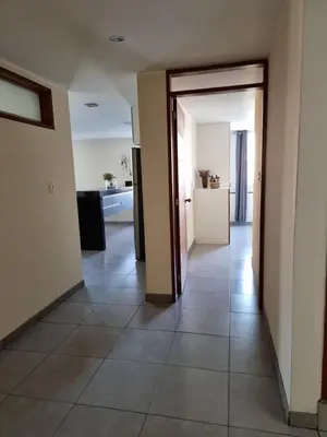 a hallway with an open door to a kitchen at Hermoso Departamento en Pueblo Libre in Lima