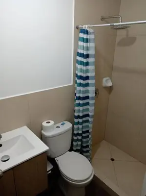 a bathroom with a toilet and a sink and a shower at Apartamento cómodo, como tu hogar in Lima