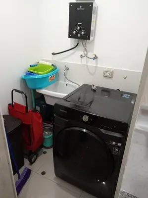 a black microwave in a kitchen with a red suitcase at Apartamento cómodo, como tu hogar in Lima