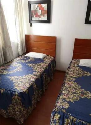 a bedroom with two beds and a window at Edificio La Católica in Lima