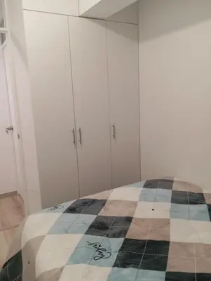 a bedroom with a bed and white cabinets at Alquiler de habitación en un bonito y cálido departamento muy bien ubicado en Barranco in Lima