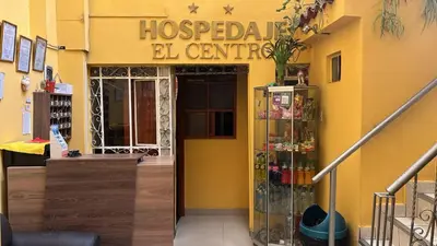 a store with a yellow building with a pharmacy at Hospedaje El Centro in Ayacucho