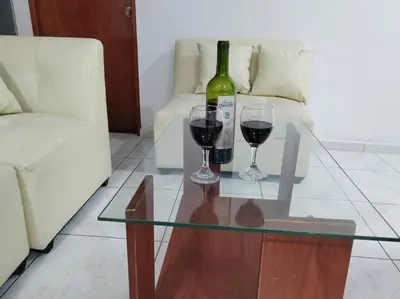 a glass table with two wine glasses and a bottle of wine at Apartamento de Kelita in Ayacucho