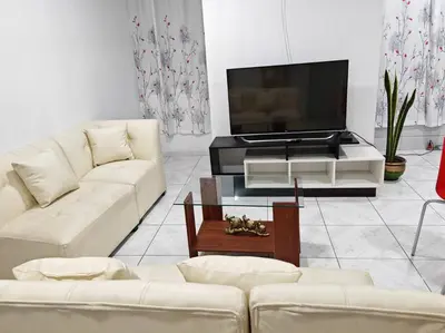a living room with white furniture and a flat screen tv at Apartamento de Kelita in Ayacucho